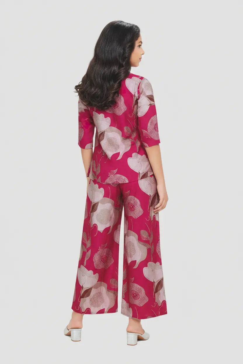 Woman wearing a pink floral jumpsuit on a white background