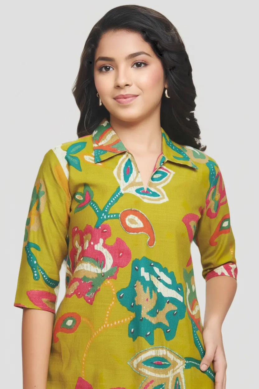 Woman wearing a colorful patterned green dress against a plain background