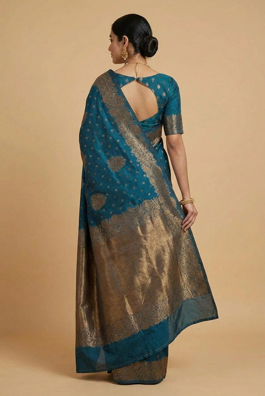 Woman wearing a blue and gold saree on a beige background