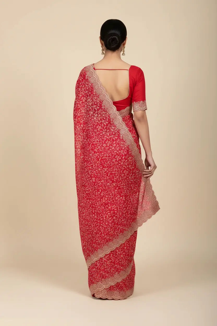 Red saree with white patterns on a beige background