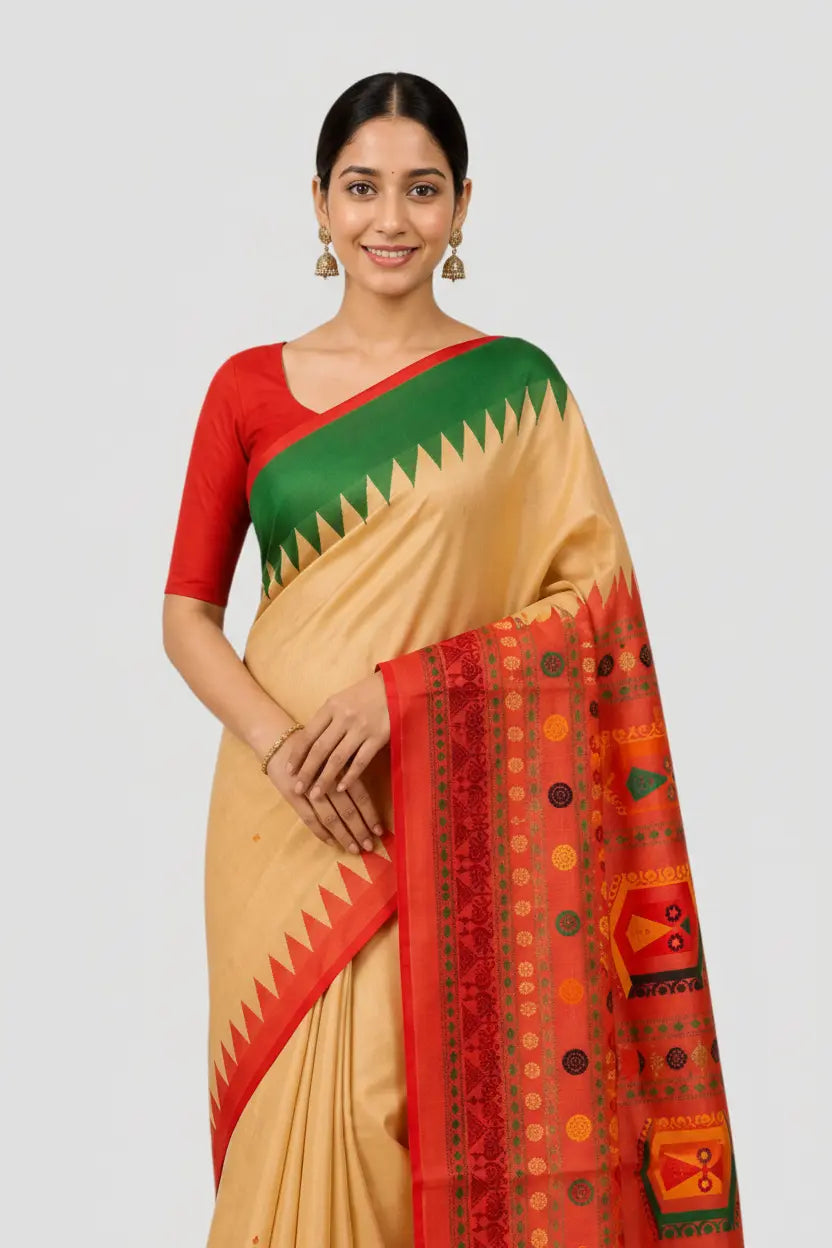 Woman wearing a traditional saree with red and green border on a plain background
