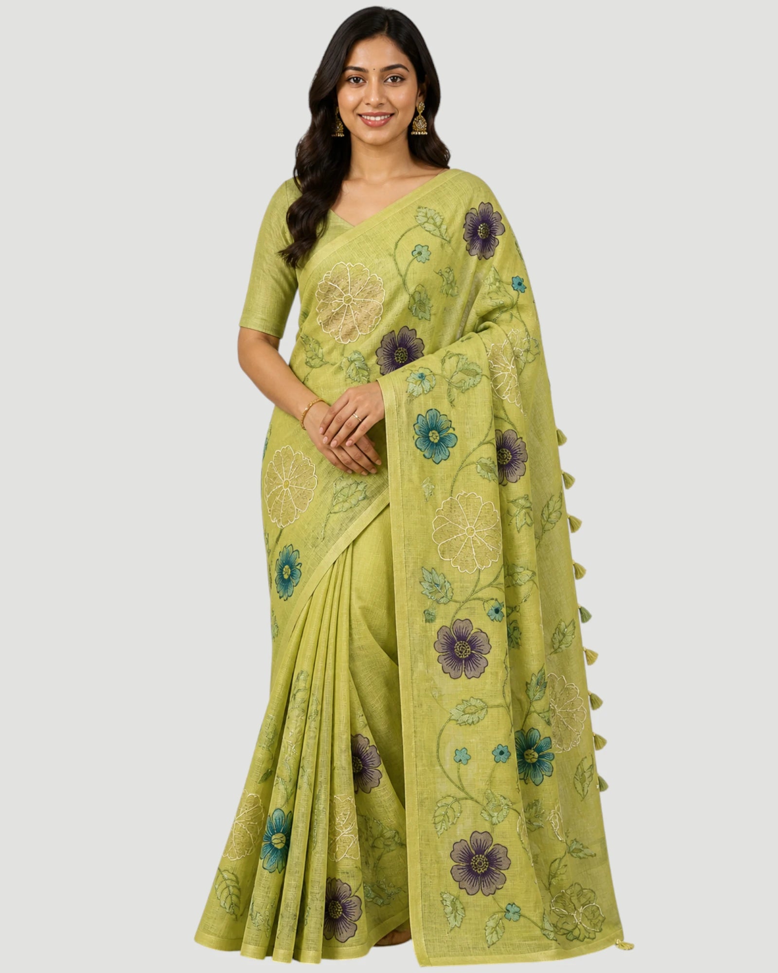 Woman wearing a green saree with floral patterns on a white background