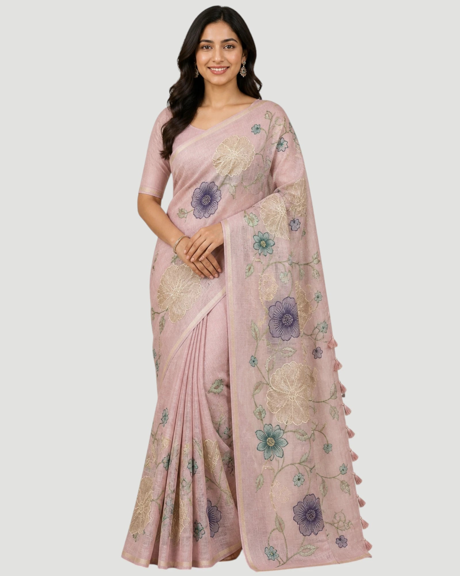Woman wearing a pink saree with floral patterns on a white background