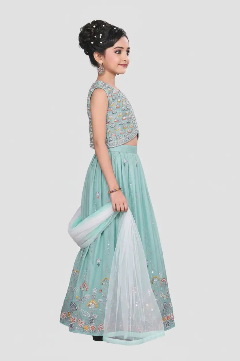 Woman wearing a light blue traditional outfit with a white dupatta on a gray background