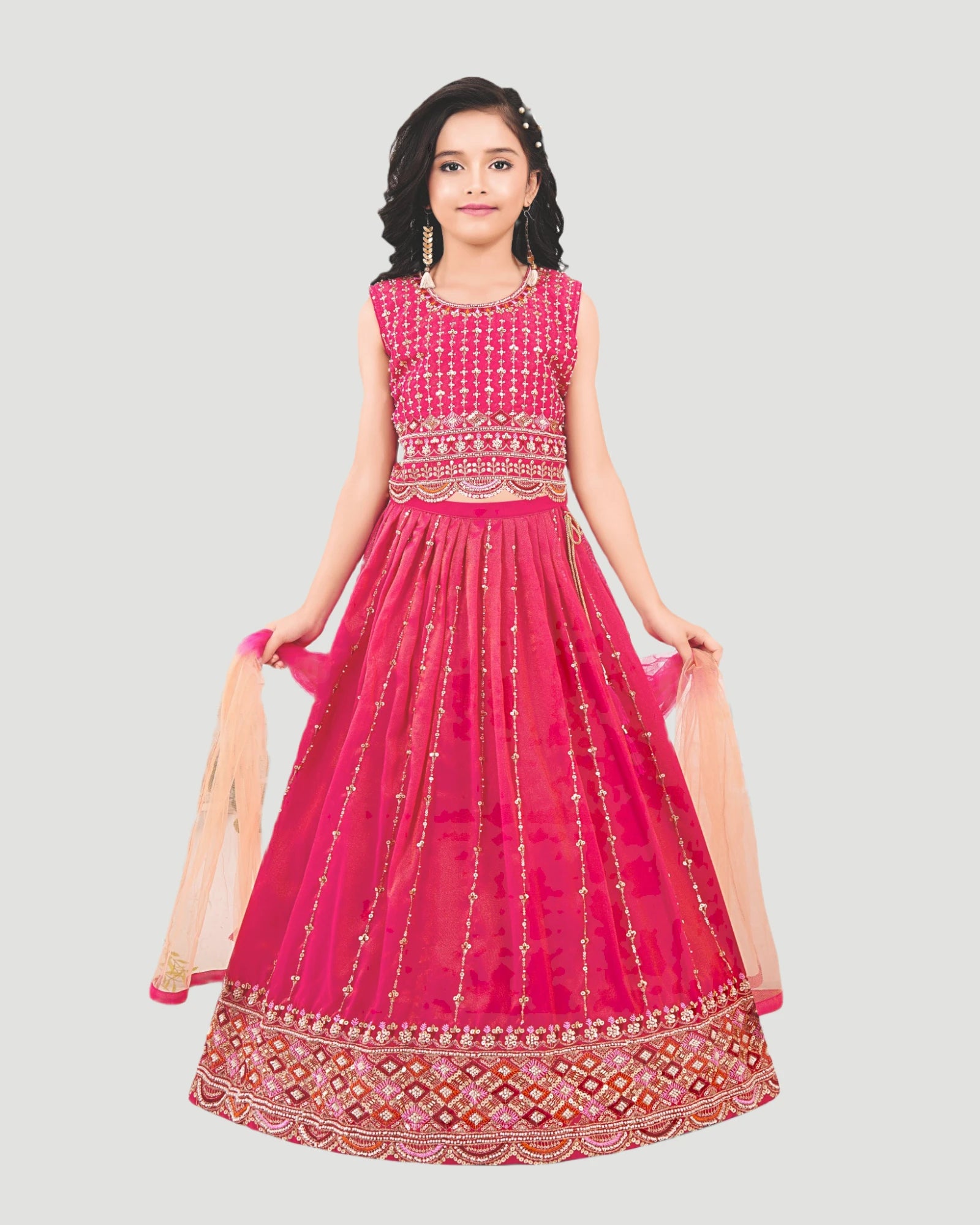 Woman wearing a pink traditional outfit with intricate designs on a gray background