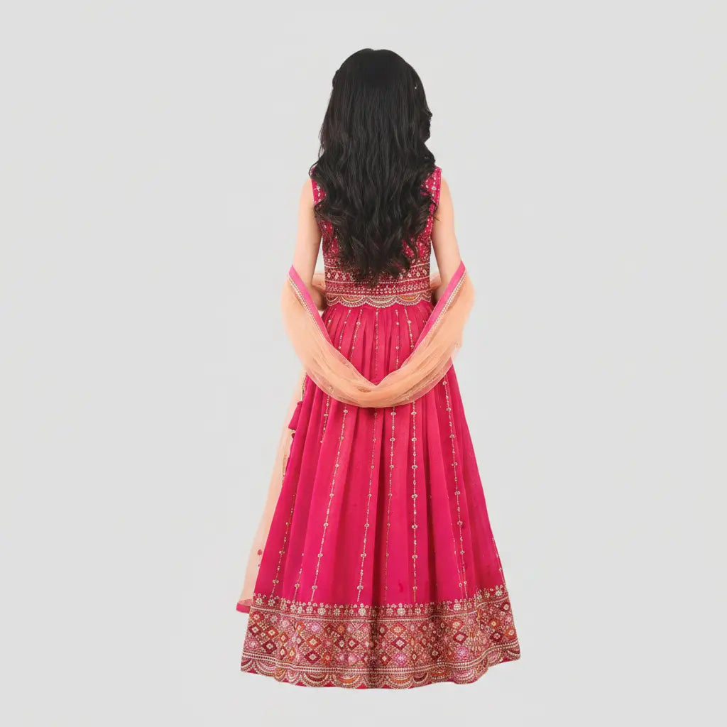 Woman wearing a pink traditional outfit with intricate designs on a light gray background