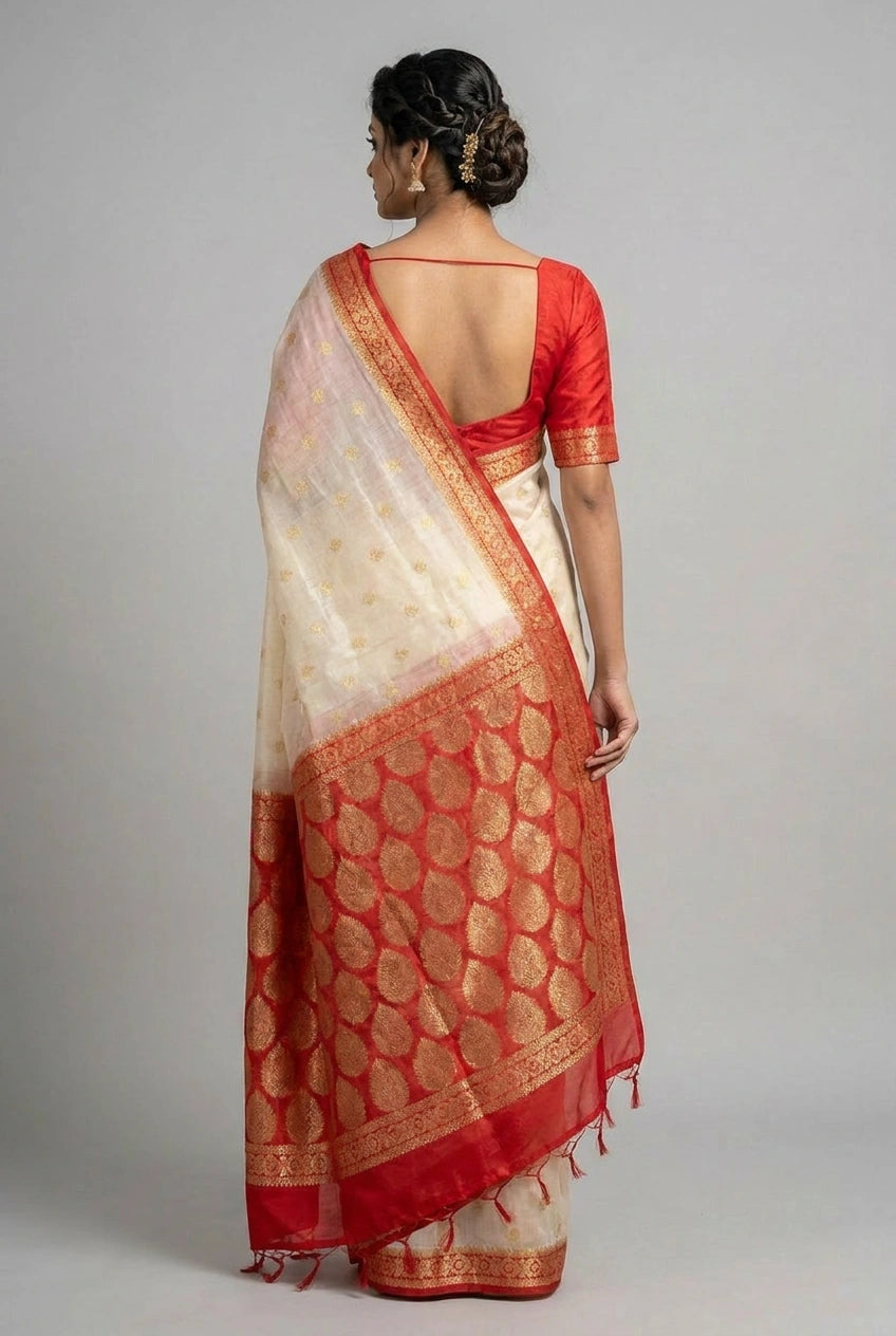 Woman wearing a red and white saree with a plain background