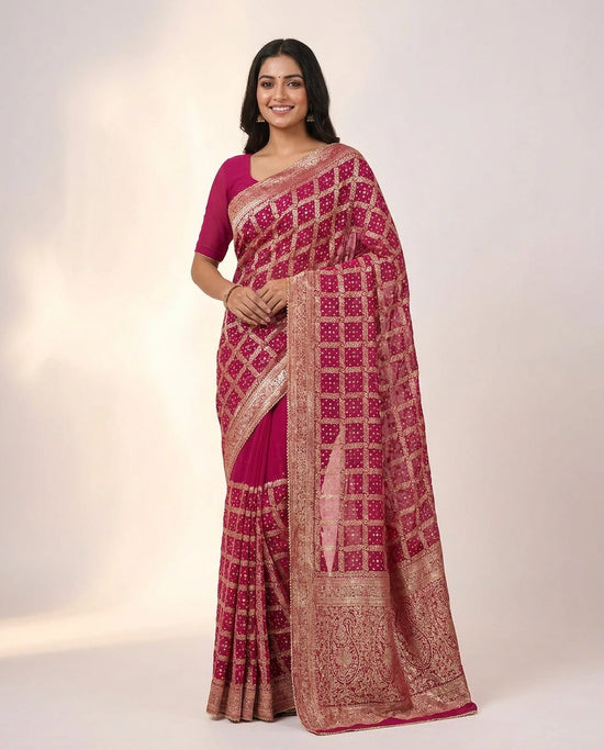 Woman wearing a pink and red saree with a white background