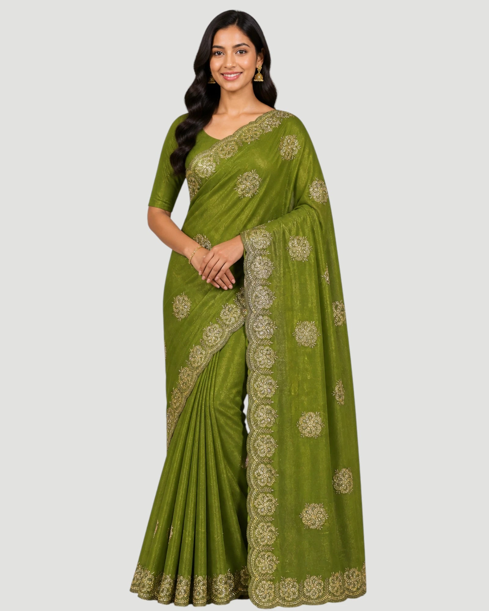 Woman wearing a green saree with gold embroidery on a white background