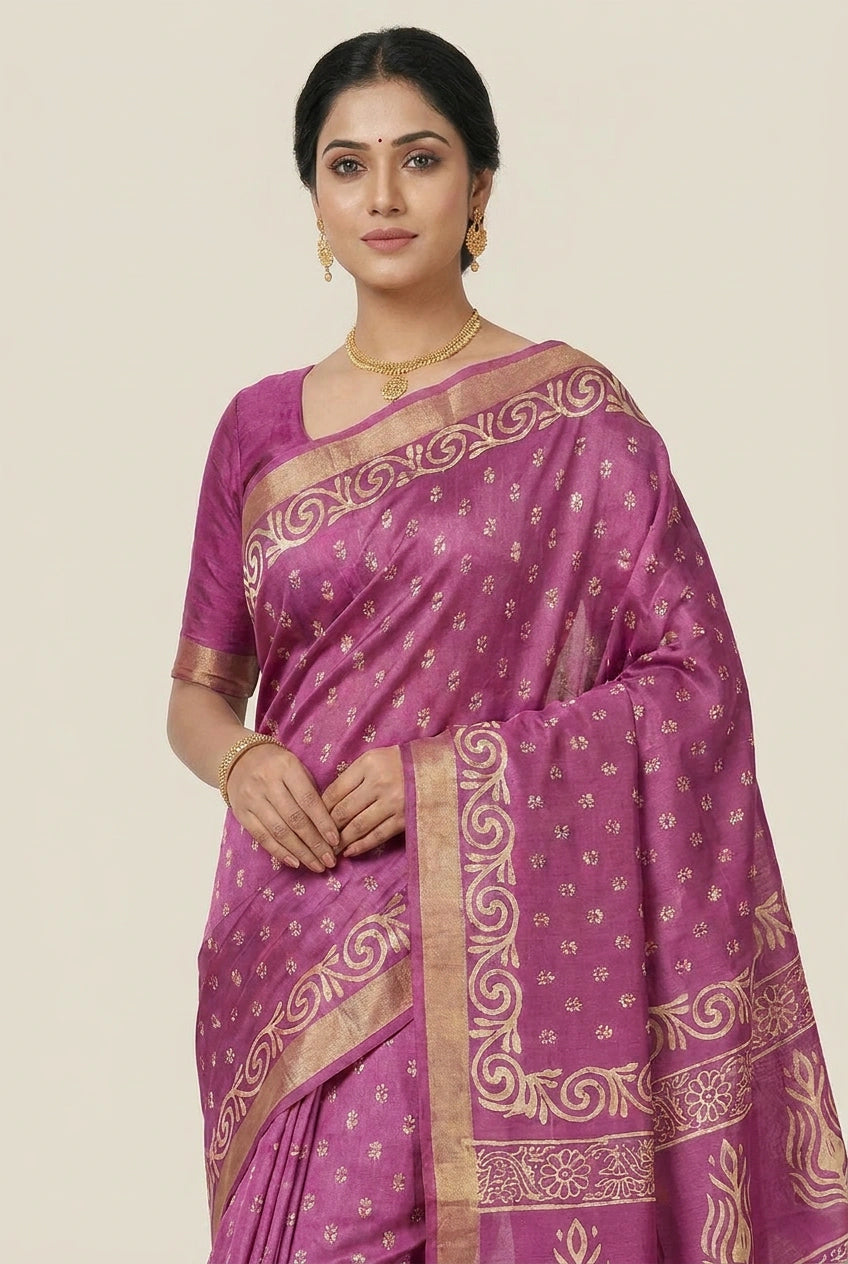Woman wearing a purple saree with gold patterns on a beige background