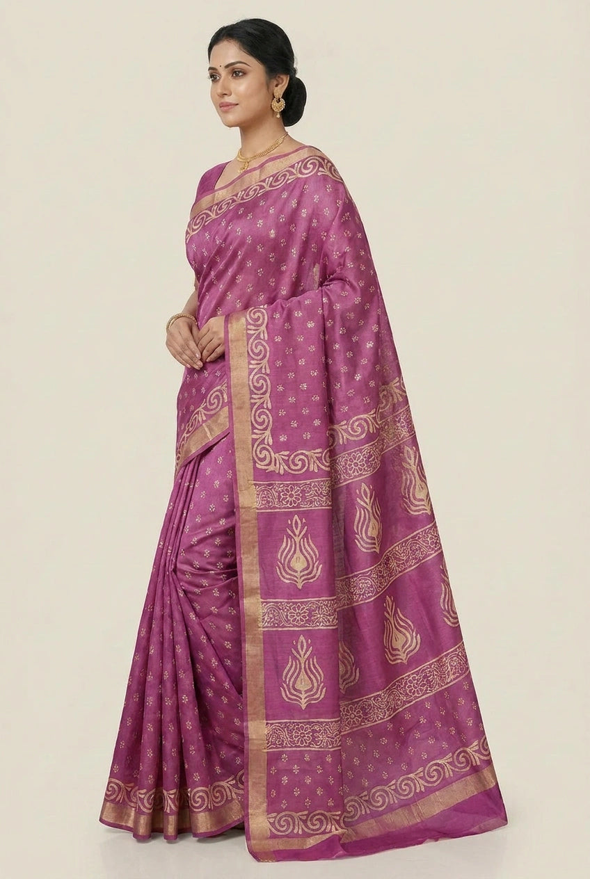 Woman wearing a purple saree with gold patterns on a beige background