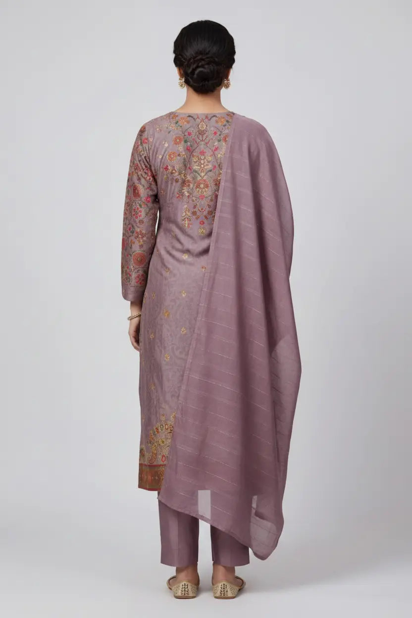 Woman wearing a traditional outfit with a floral blouse and mauve saree on a white background