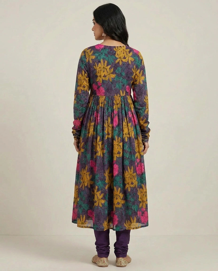 Woman wearing a colorful floral dress with long sleeves on a plain background