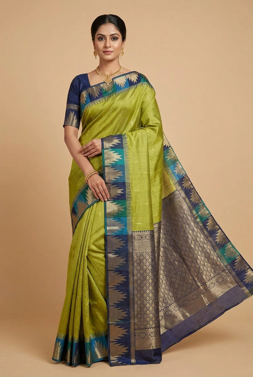 Woman wearing a green saree with blue and gold border on a beige background