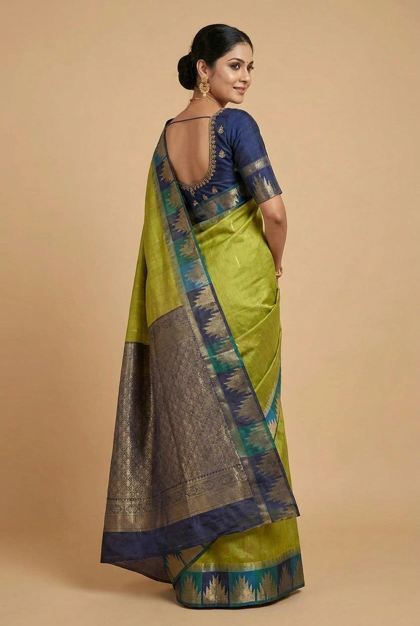 Woman wearing a green saree with a blue blouse against a beige background