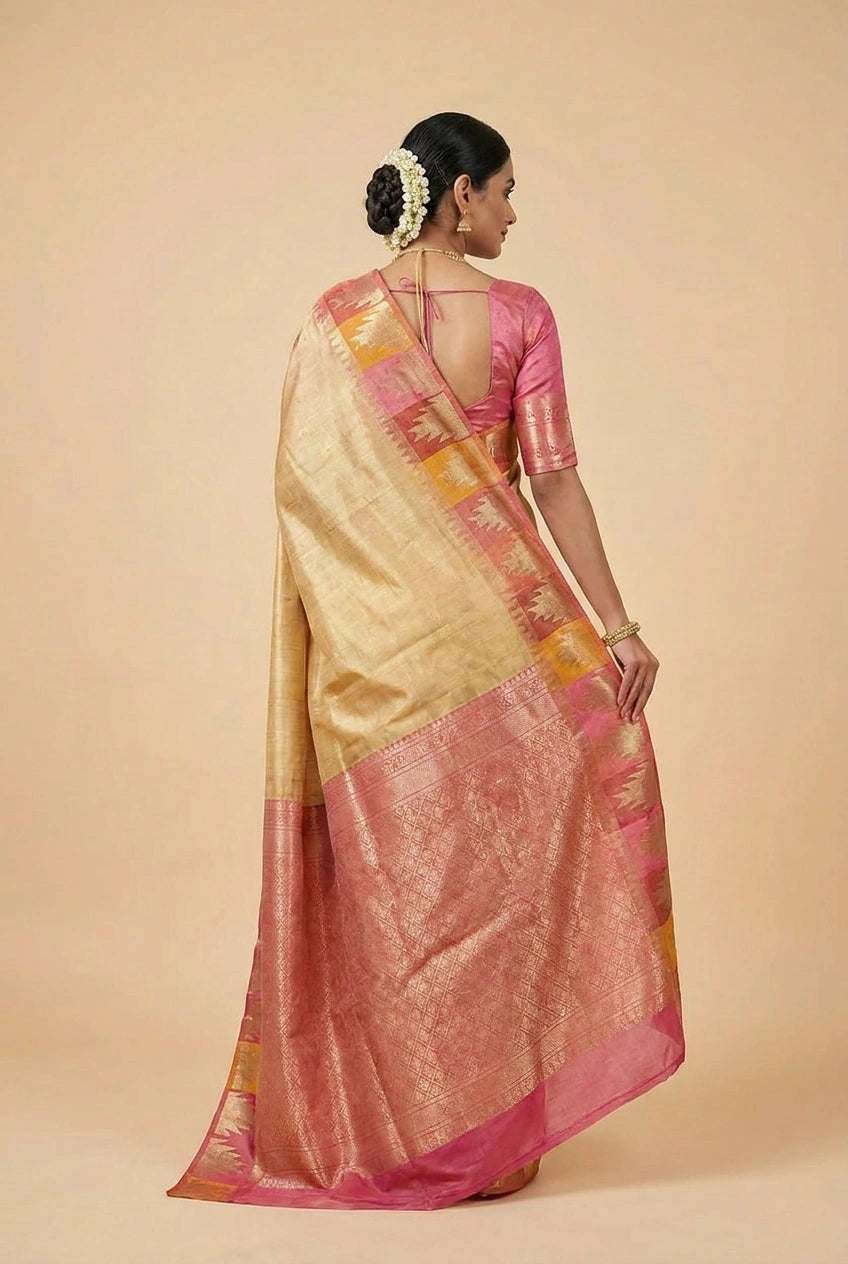 Woman wearing a traditional saree with a pink and gold border on a beige background