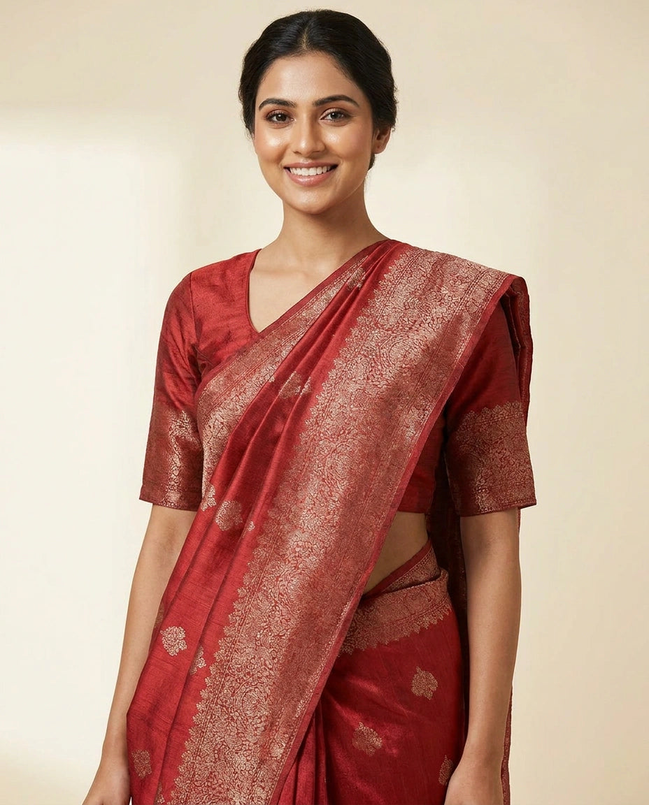 Woman wearing a red saree with a beige background