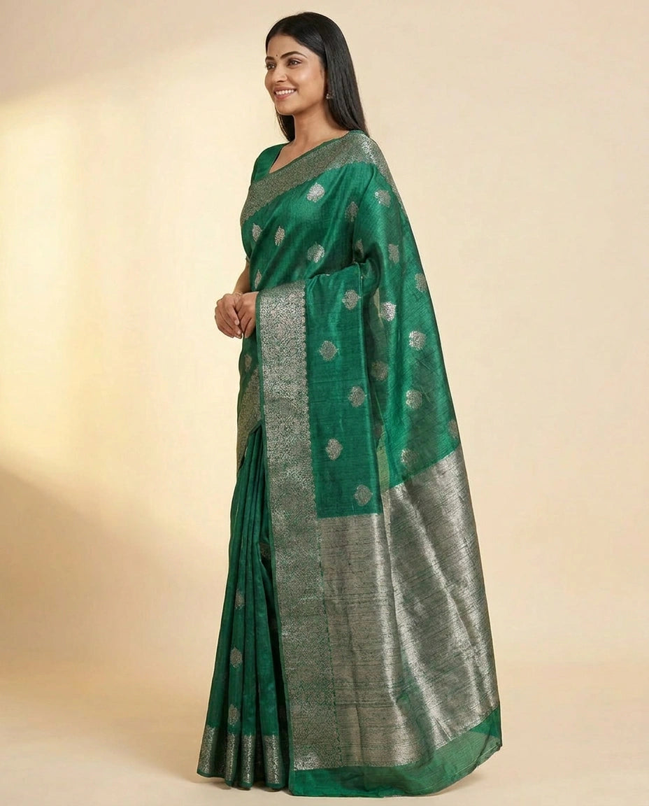 Woman wearing a green saree with a subtle pattern on a beige background