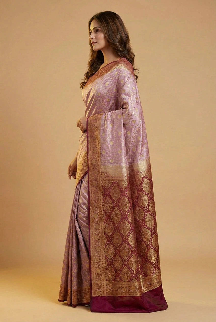 Woman wearing a traditional saree with a patterned border on a beige background