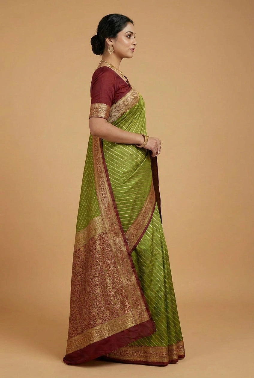 Woman wearing a green saree with a brown border on a beige background