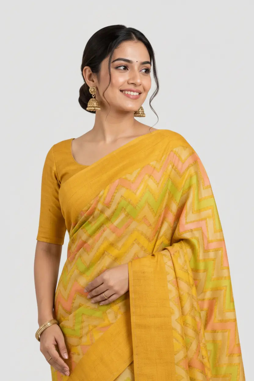 Woman wearing a yellow saree with a pattern on a white background