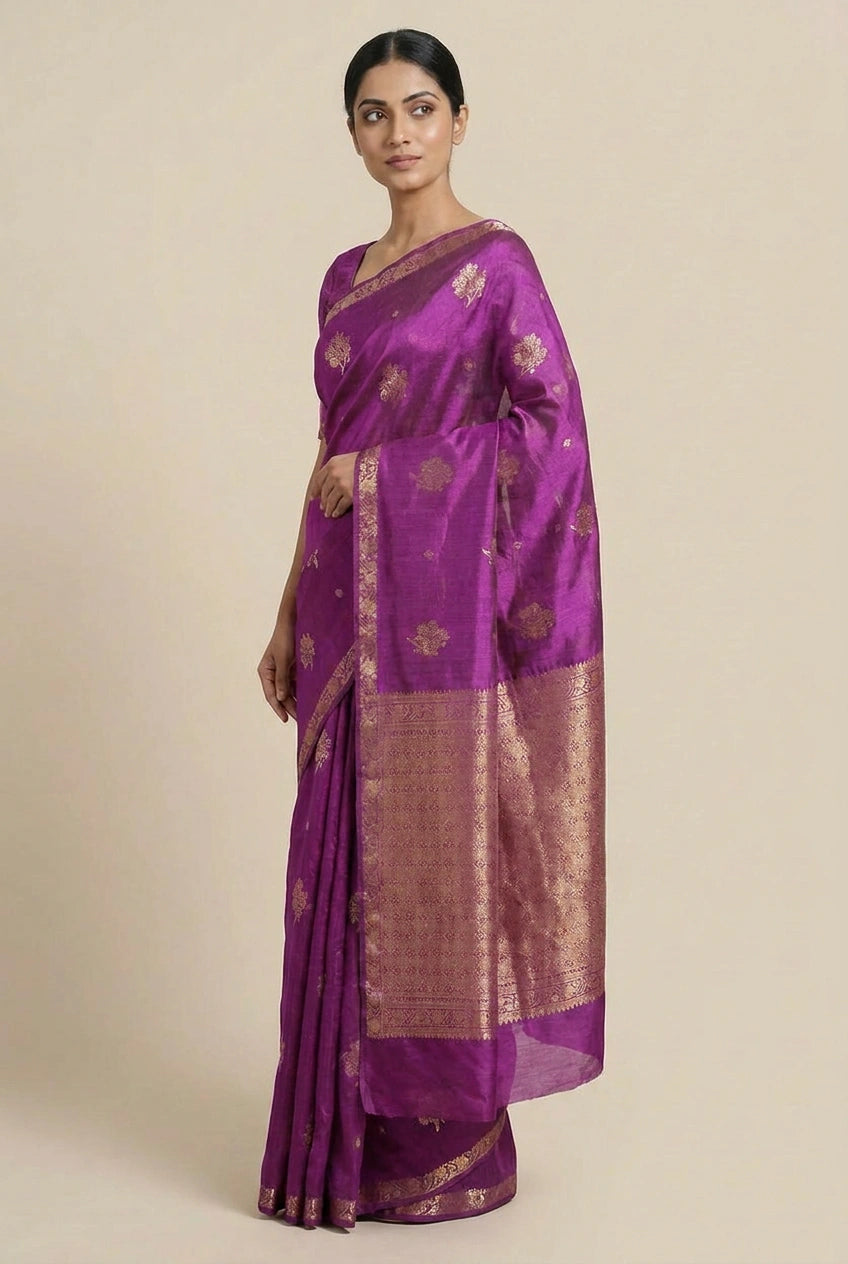 Woman wearing a purple saree with gold patterns on a beige background
