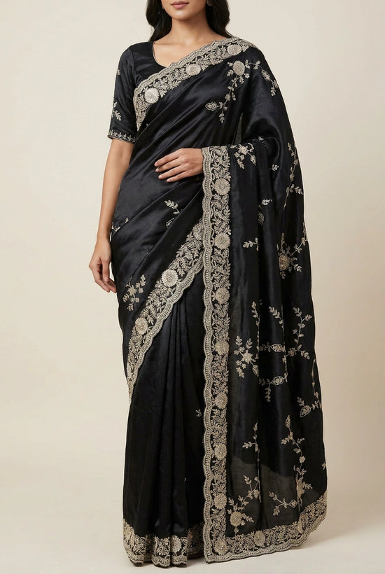 Black saree with intricate gold embroidery on a neutral background