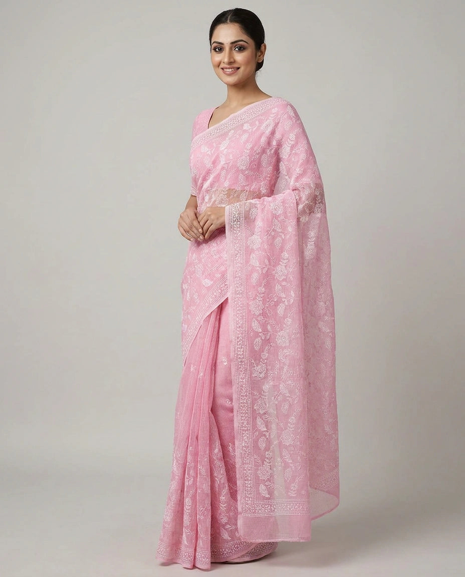 Woman wearing a pink saree with a white border on a gray background