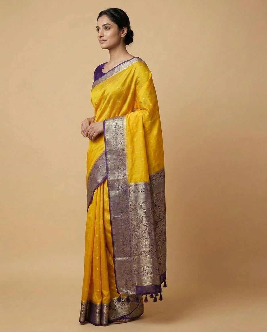 Woman wearing a yellow saree with a purple border on a beige background