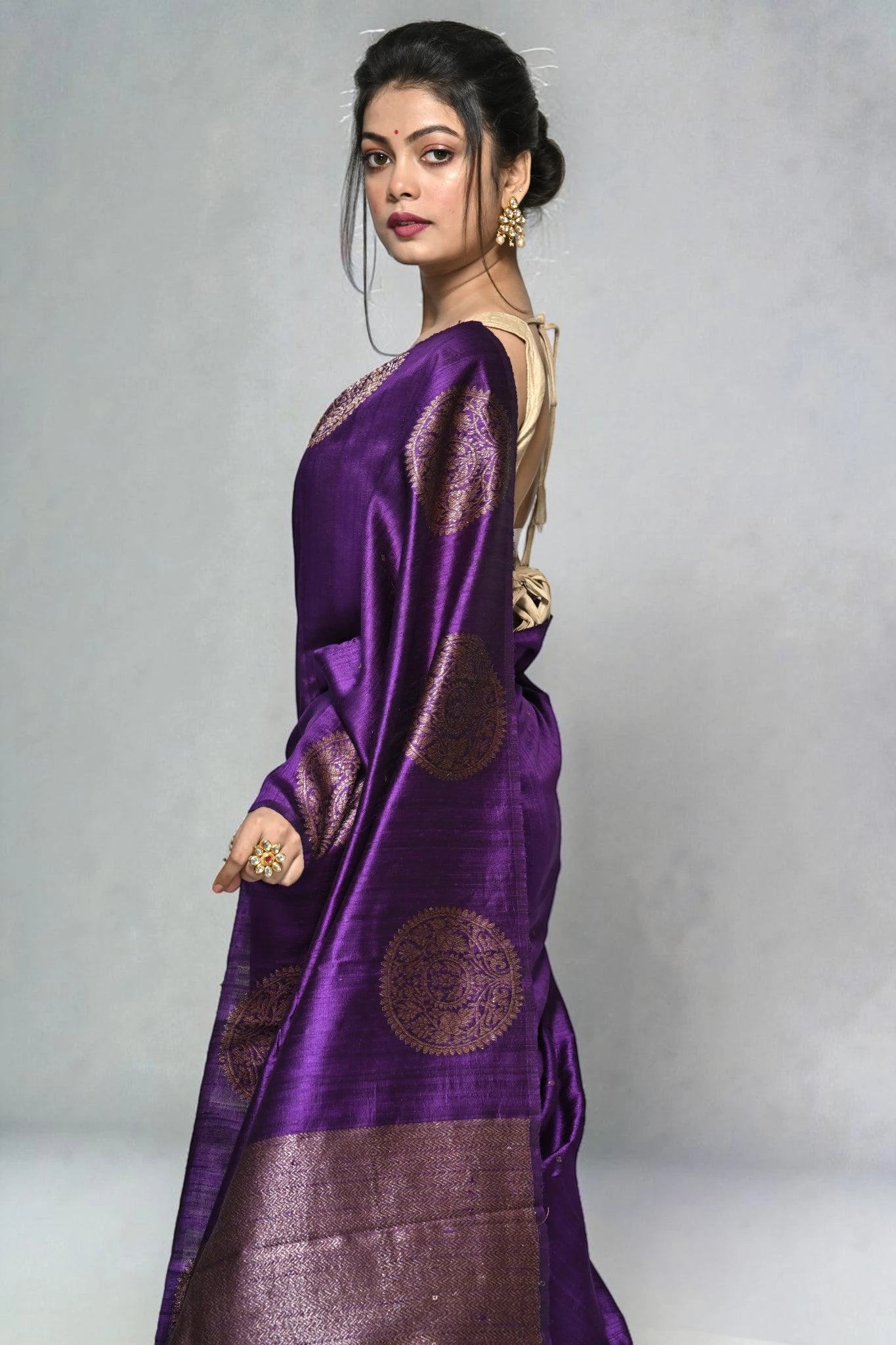 Woman wearing a purple saree with a white background