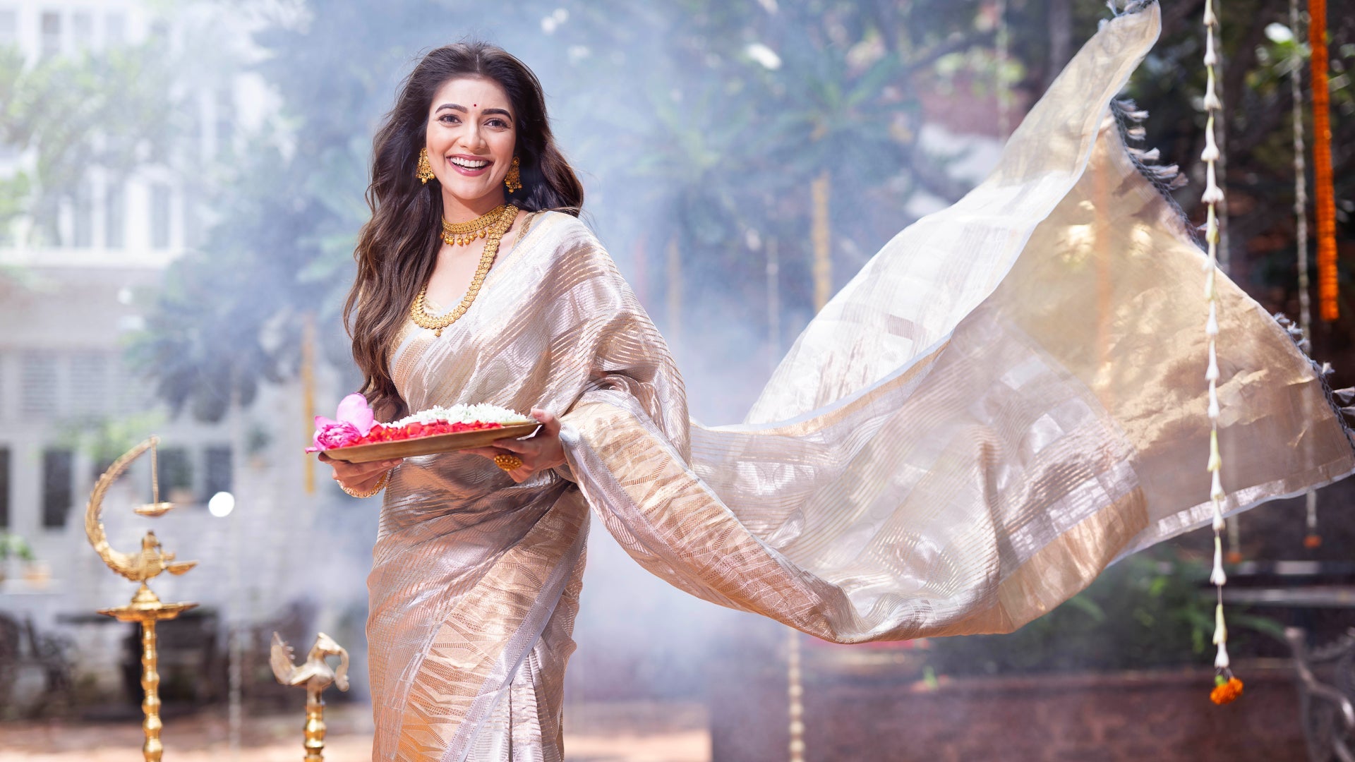Woman in a traditional saree with decorative elements in an outdoor setting