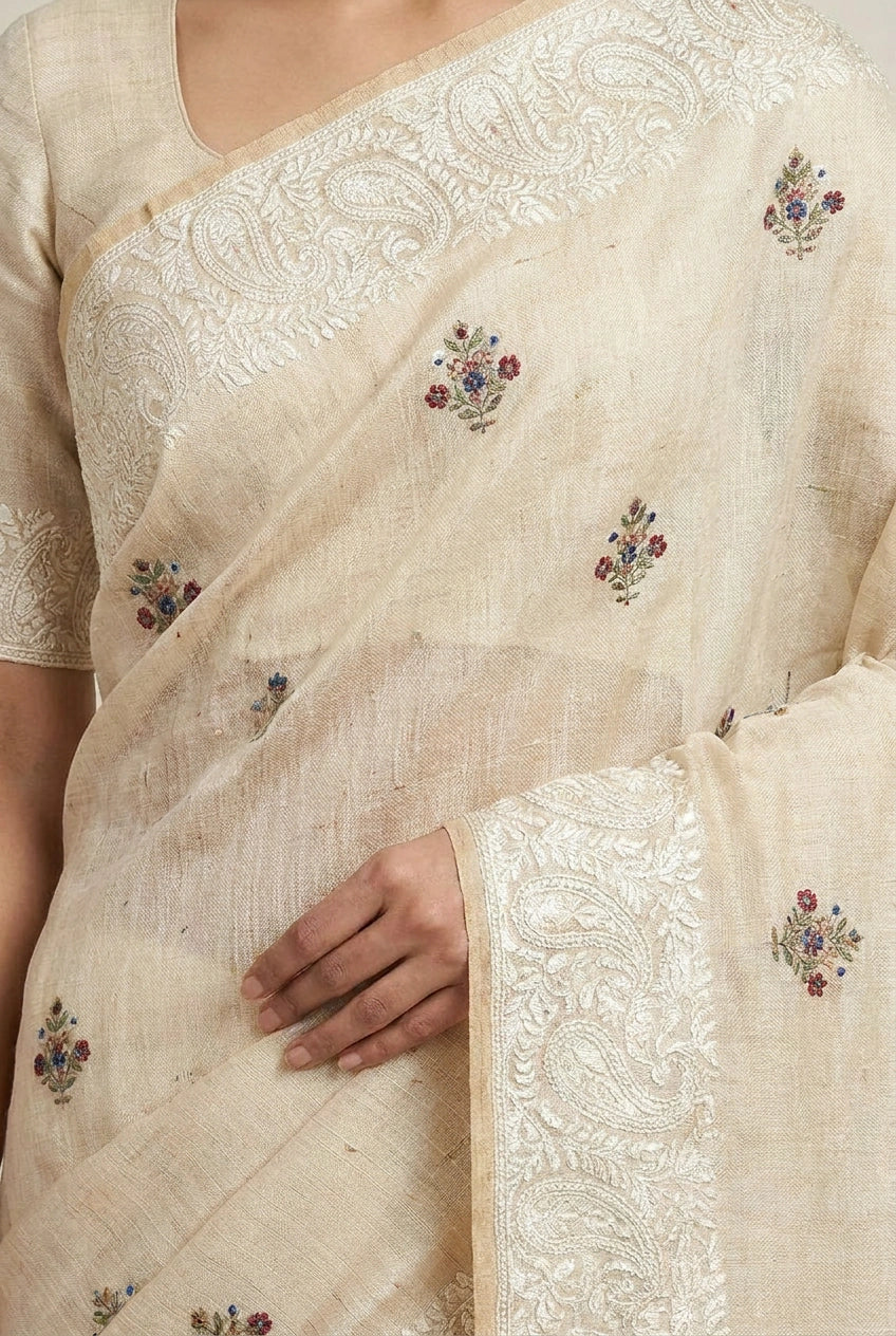 Close-up of a cream saree with floral embroidery