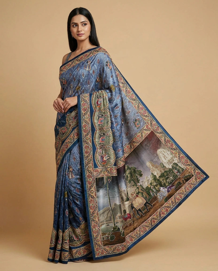 Woman wearing a blue saree with intricate patterns on a beige background