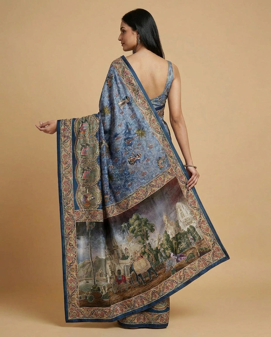 Woman wearing a blue saree with intricate patterns on a beige background