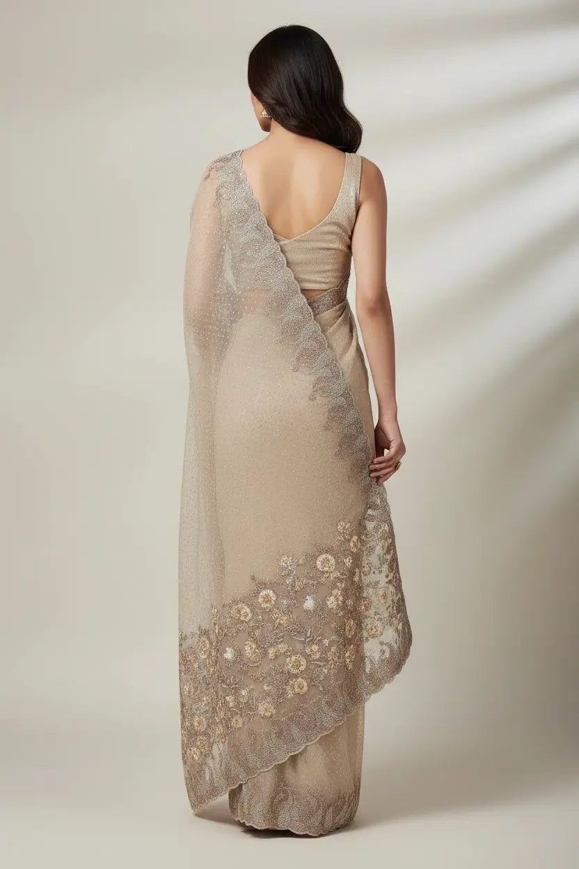 Woman wearing a beige evening gown with floral embroidery on a plain background