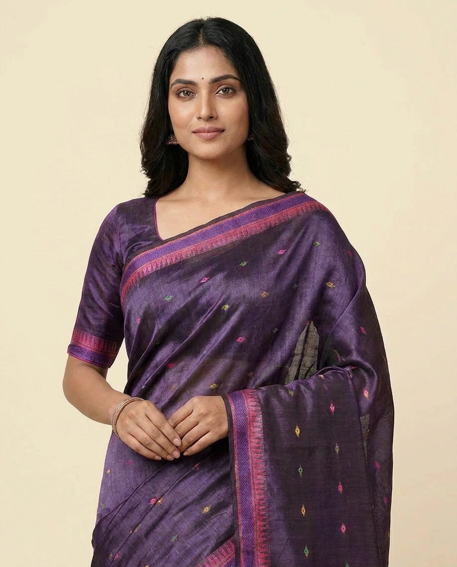 Woman wearing a purple saree with a beige background