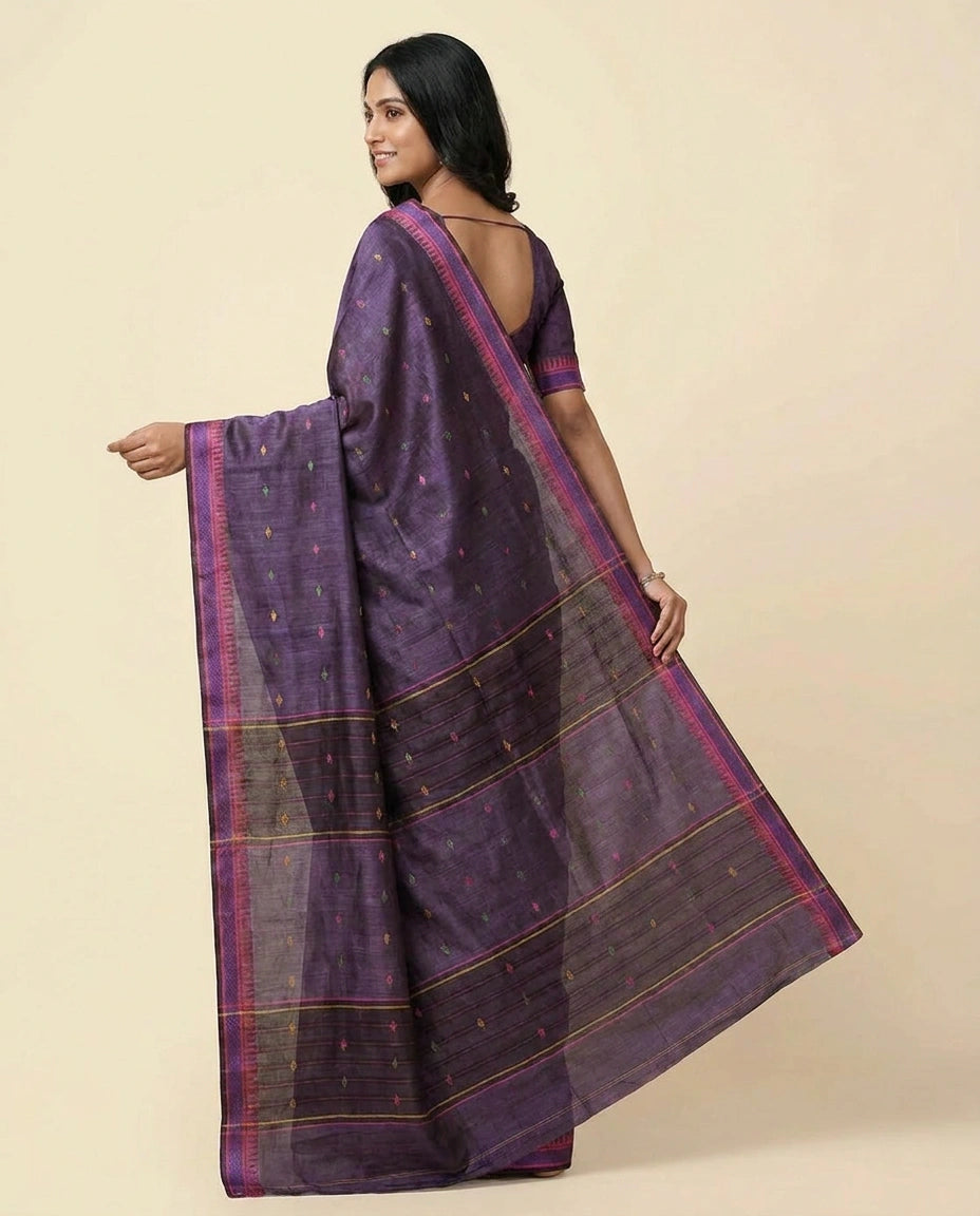 Woman wearing a purple saree with a beige background