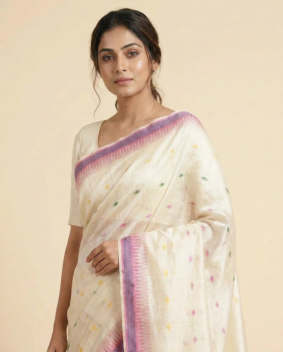 Woman wearing a white saree with colorful border on a beige background