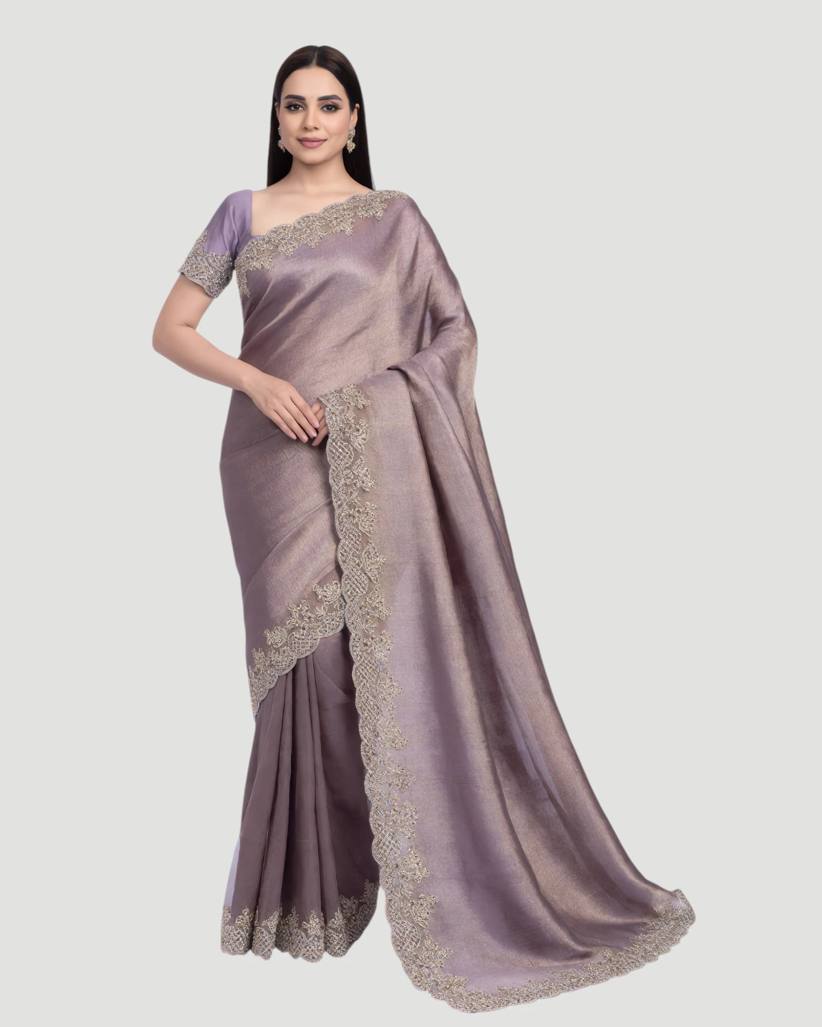 Woman wearing a mauve saree with intricate designs on a light gray background