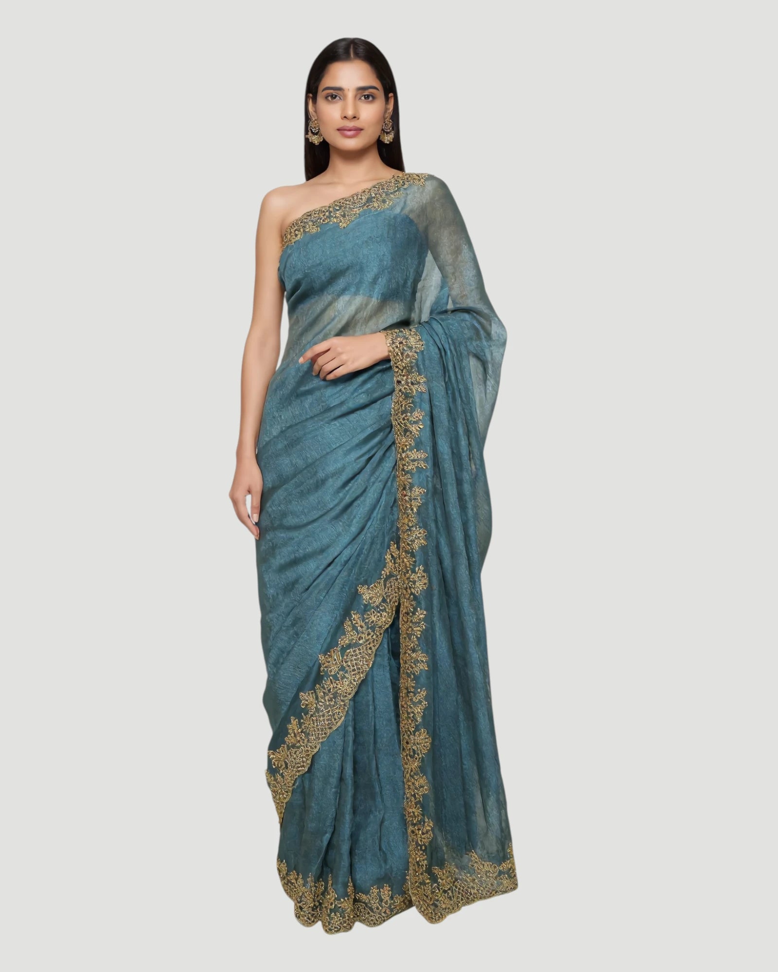Woman wearing a blue saree with gold embroidery on a white background