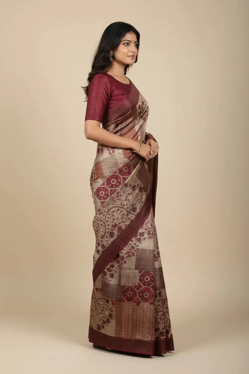 Woman wearing a patterned saree with a plain background