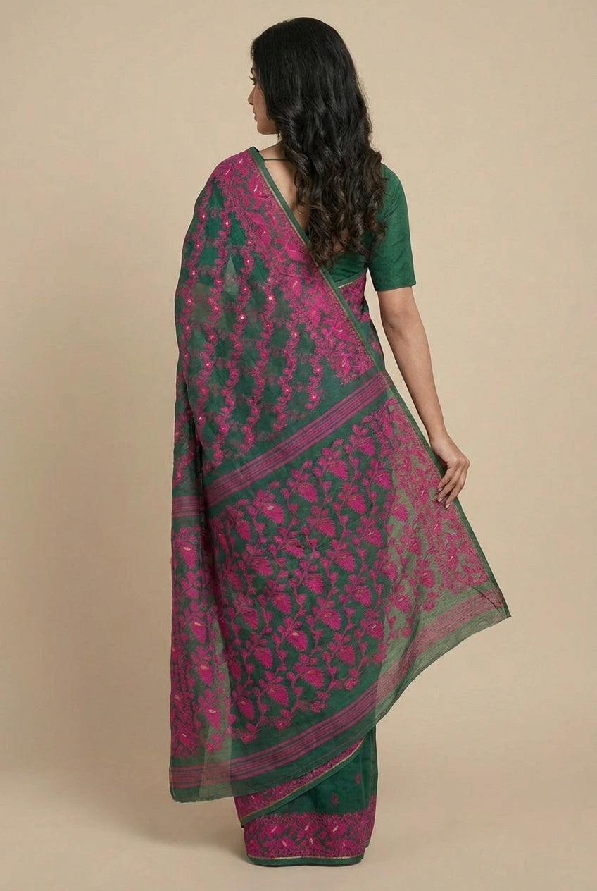 Woman wearing a green and pink saree with a beige background
