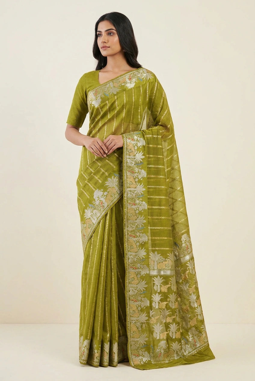 Woman wearing a green saree with floral patterns on a beige background