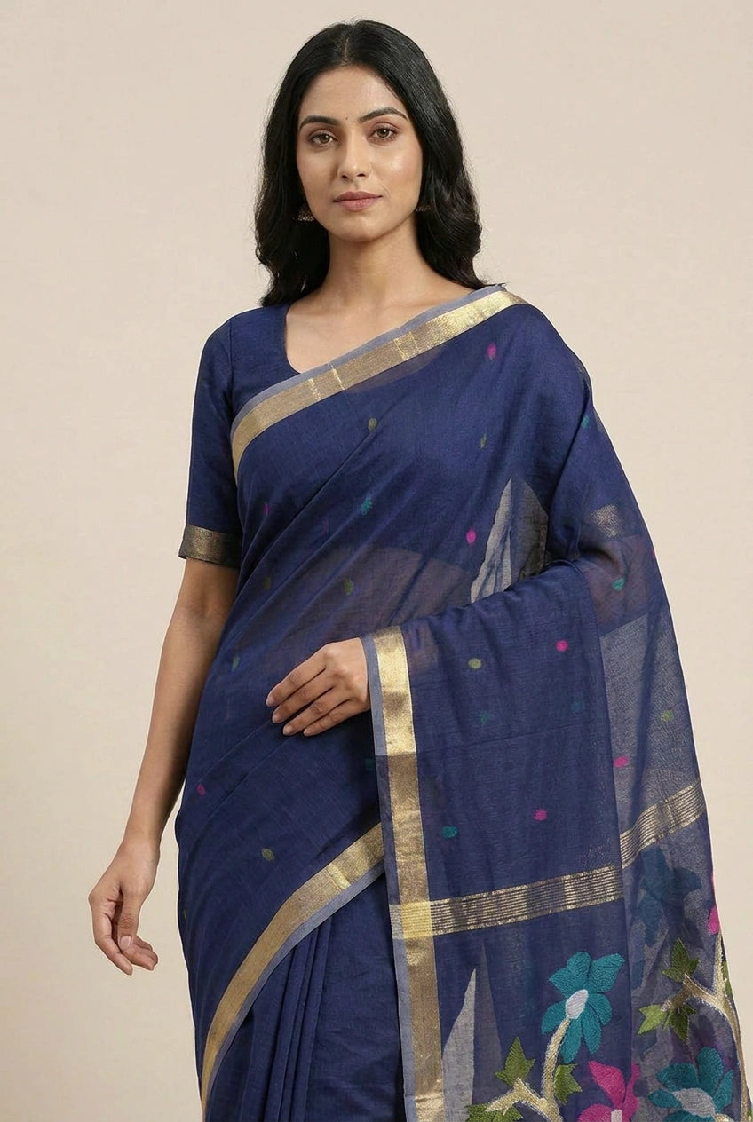 Woman wearing a blue saree with gold border on a beige background