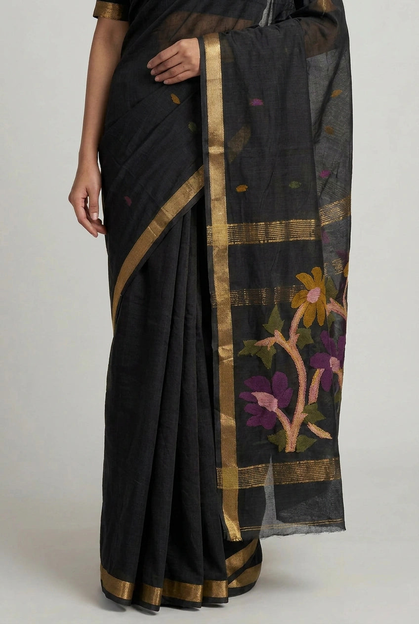 Black saree with floral patterns and gold border on a plain background