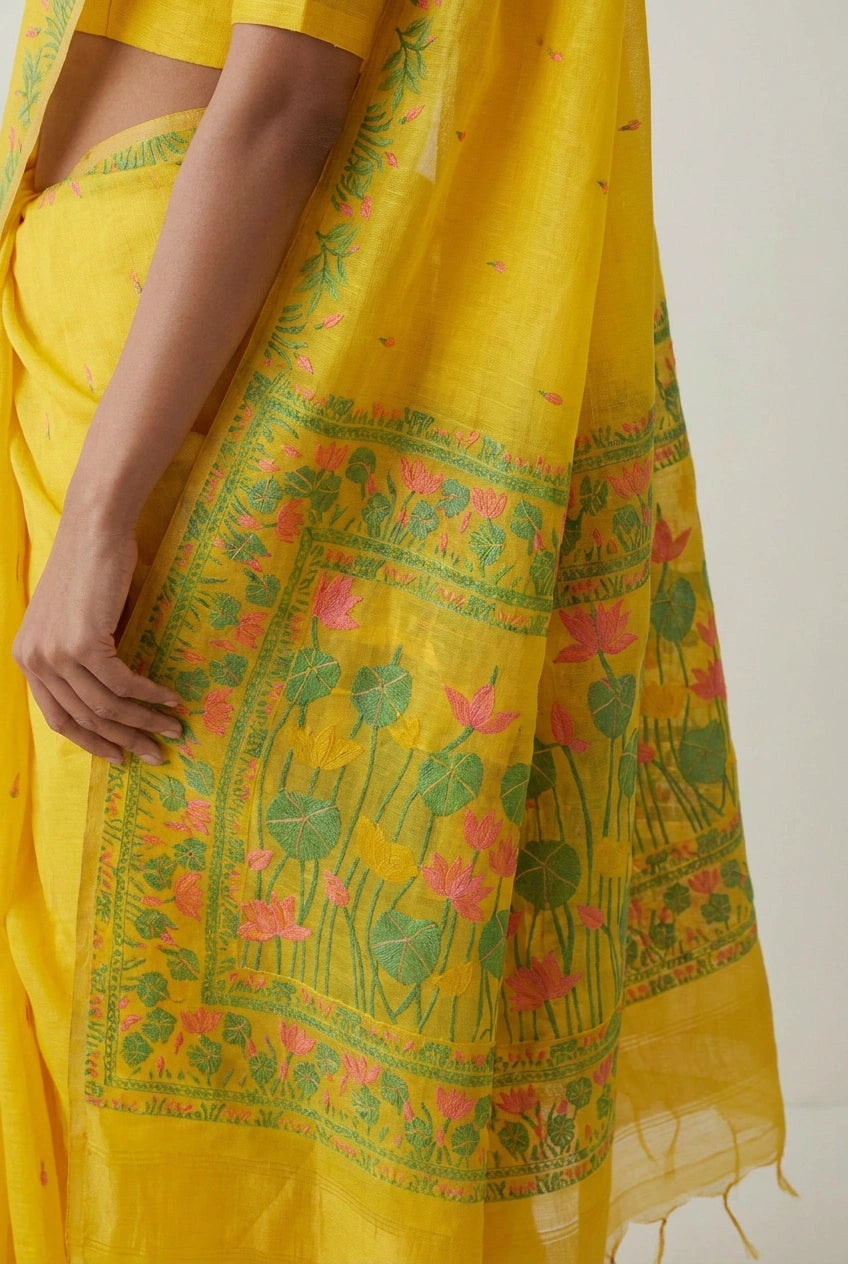 Yellow saree with floral patterns on a plain background