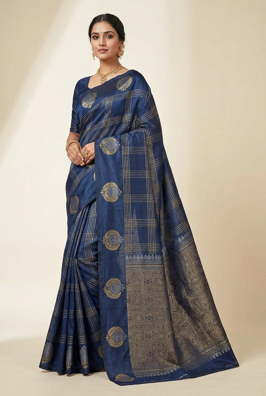 Woman wearing a blue saree with gold patterns on a beige background