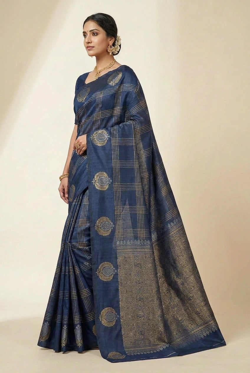 Woman wearing a blue saree with gold patterns on a beige background