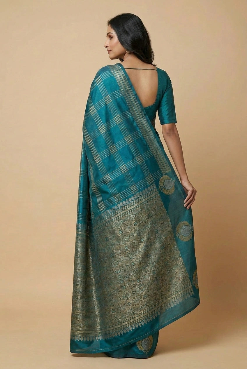 Woman wearing a teal saree with a beige background