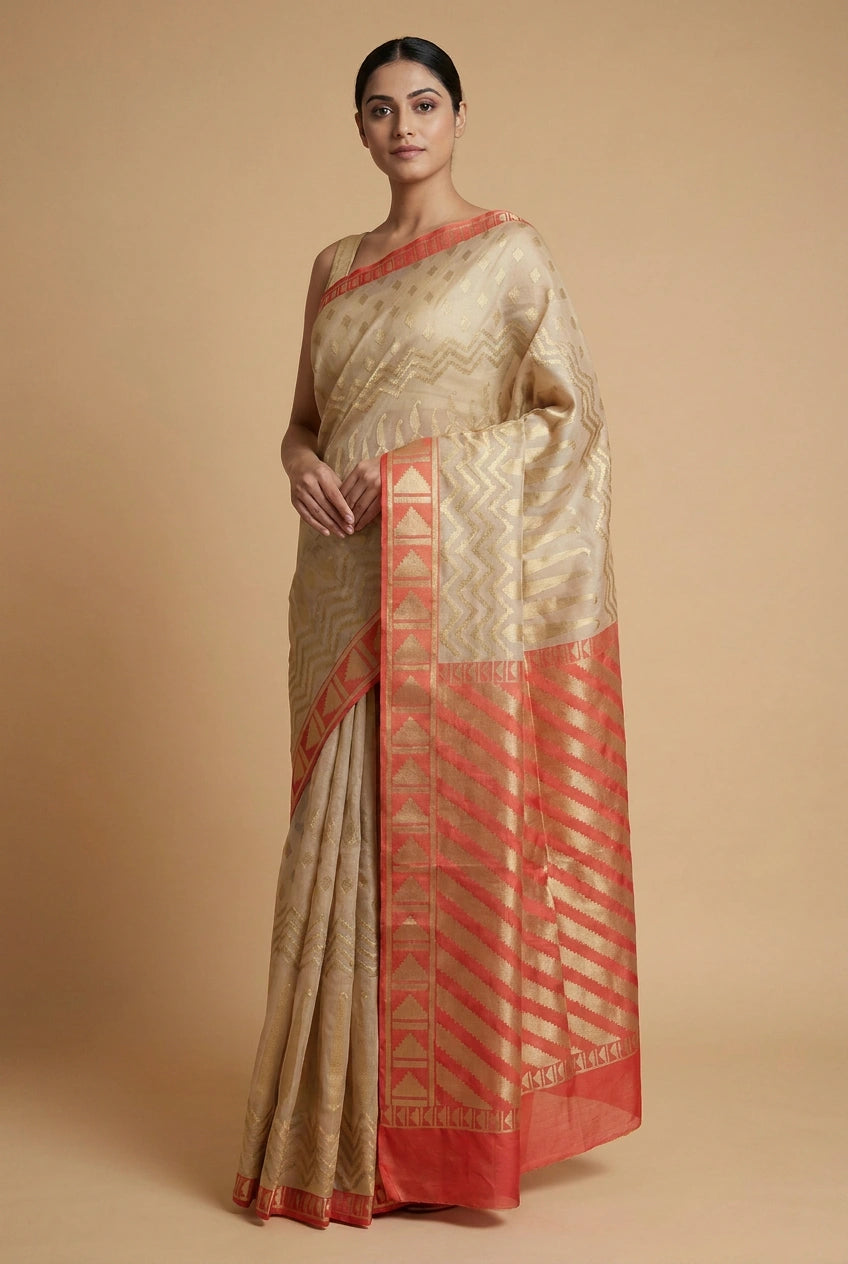 Woman wearing a traditional saree with beige and red patterns on a beige background